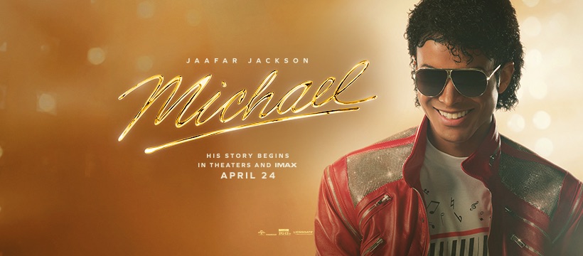 Promotional movie poster for the 2026 biographical film Michael. Against a warm, golden, bokeh-lit background, Jaafar Jackson appears on the right side as Michael Jackson, wearing dark aviator sunglasses and a red-and-silver leather jacket over a white shirt with a musical-keyboard graphic. The gold cursive title text reads "Michael" with "Jaafar Jackson" above it and release details below.