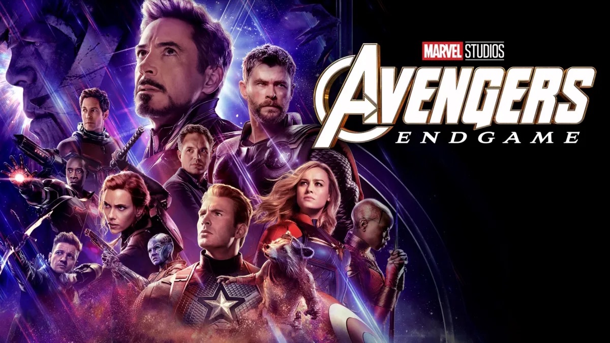 Promotional ensemble poster for Avengers: Endgame featuring prominent characters including Iron Man, Captain America, Thor, Black Widow, Hulk, and Captain Marvel arranged against a cosmic, purple-hued backdrop with the official movie logo on the right.